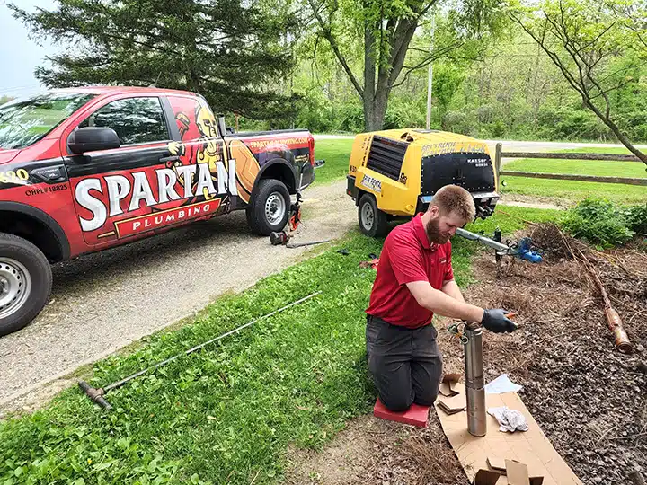 Spartan plumber working on piping in front of Spartan truck in Dayton, OH.